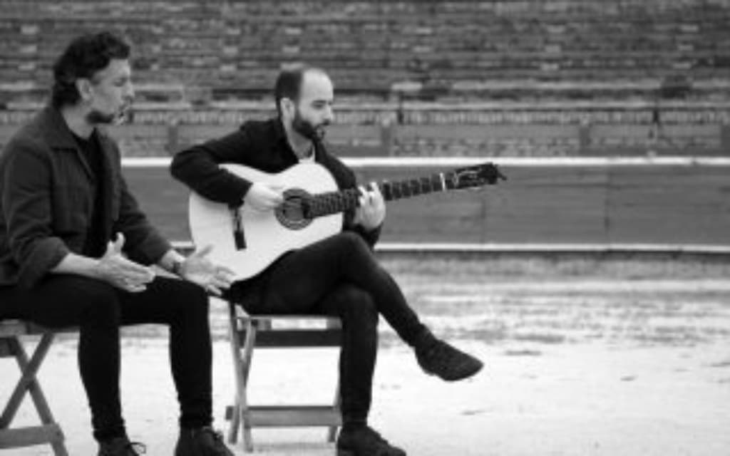 dos hombres tocando la guitarra