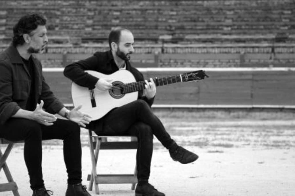 dos hombres tocando la guitarra